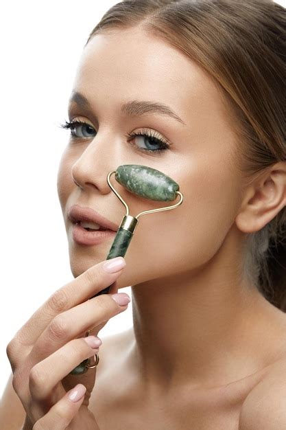 Premium Photo Beauty Skin Care Woman Using Jade Facial Roller For