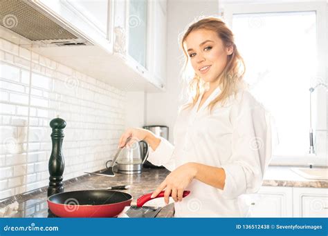 Young Woman Cooking Breakfast Stock Photo - Image of sunlight, smiling: 136512438