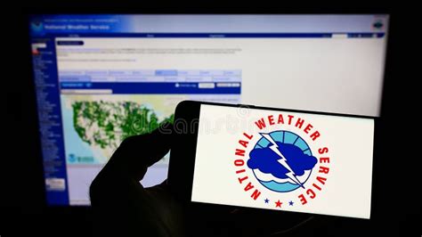 Person Holding Smartphone With Logo Of Us Agency National Weather