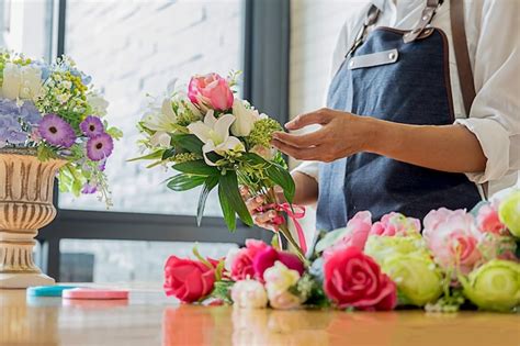 Premium Photo Midsection Of Woman Arranging Flowers In Bouquet