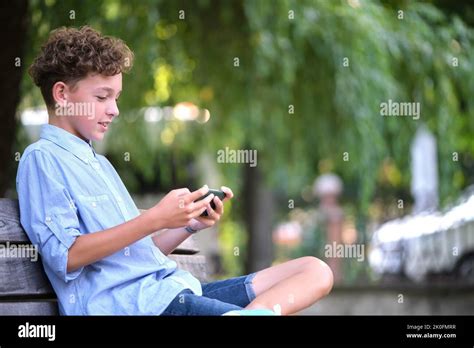 Chico Joven Navegando Su Smartphone Al Aire Libre En El Parque De Verano Uso Del Teléfono Móvil