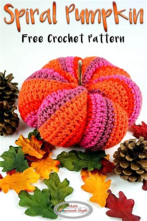 A Crocheted Pumpkin Sitting On Top Of Leaves And Pine Cones With The