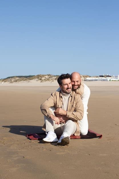 Homme Chauve étreignant Son Petit Ami Sur La Plage Photo Gratuite