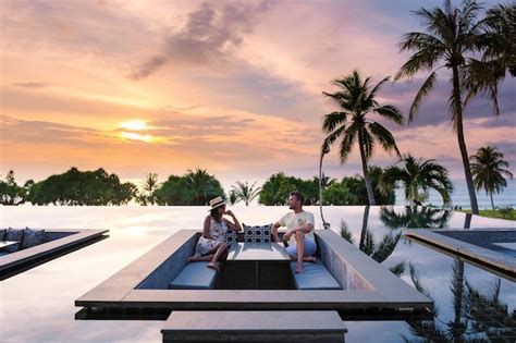 Pareja Viendo La Puesta De Sol En La Piscina Infinita En Unas