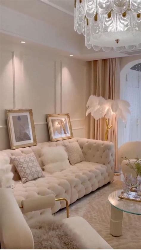 a living room filled with furniture and a chandelier hanging above the couches