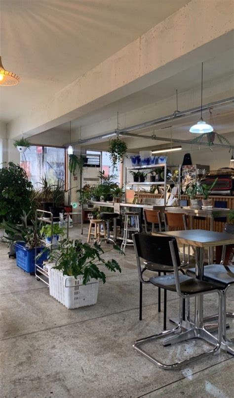 A Room Filled With Lots Of Tables And Chairs Next To Plants On The