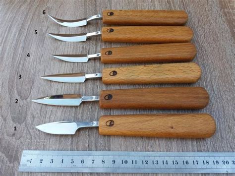 Six Knives Are Lined Up Next To A Ruler