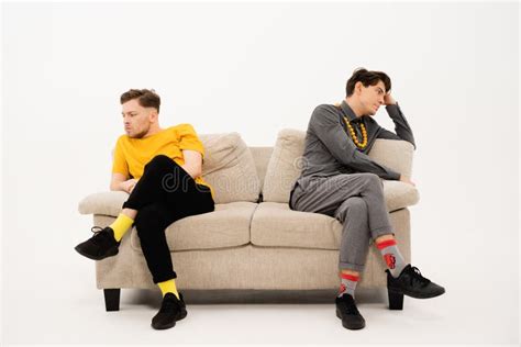 Two Guys Sitting On The Couch And Looking At The Laptop Screen Stock