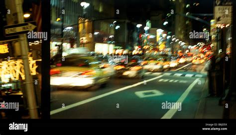 New York City street scene at night, with moving yellow taxi Stock ...