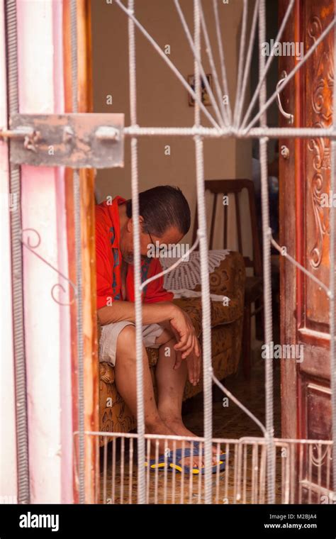 A Cuban Man Sitting On A Couch With His Head Down In Havana Cuba Stock