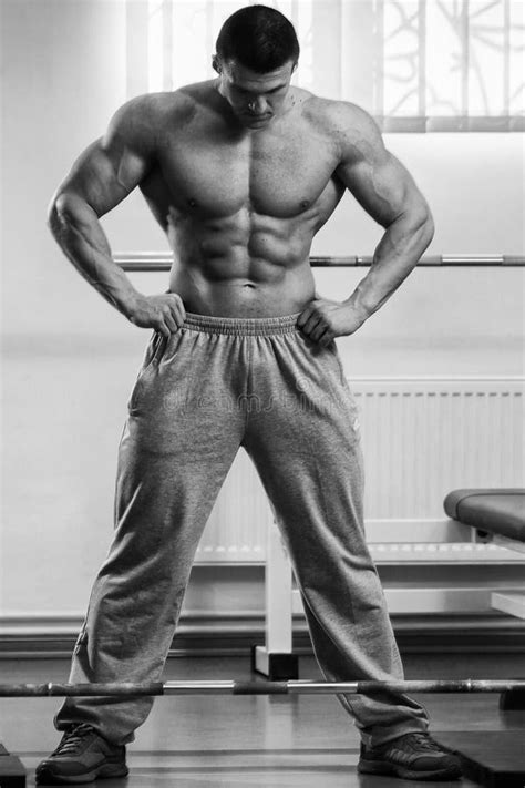 Hombre Muscular En El Gimnasio Que Realiza El Ejercicio Foto De Archivo