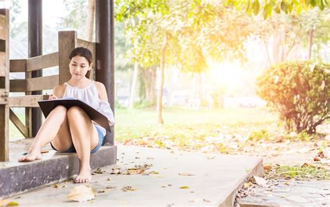 Premium Photo Woman Reading Book While Sitting Against Trees