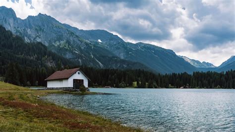 Premium Ai Image Lonely House On The Shore Of A Lake In The Mountains