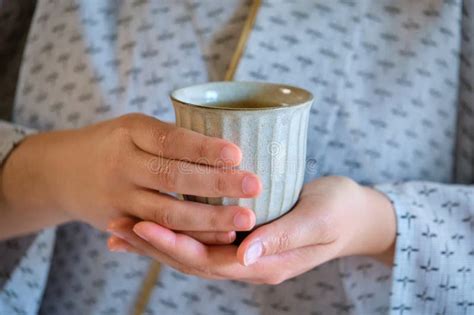 Hands Holding Japanese Kashiwa Mochi And Green Tea On Tatami Stock