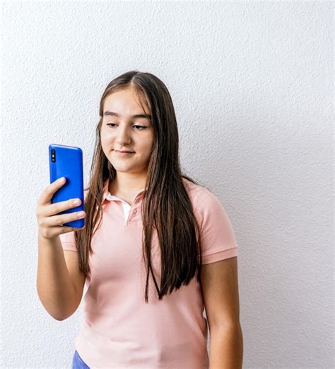 Premium Photo Young Girl Is Looking At Her Smartphone