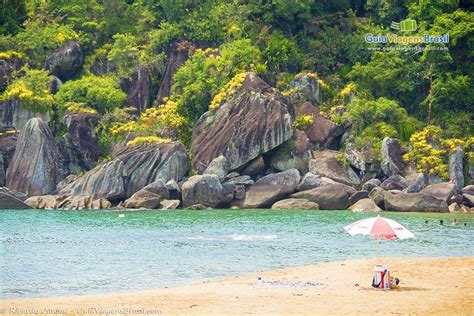 Imagem De Guarda Sol Nas Areias Da Praia E Ao Fundo Umas Pessoas Nas