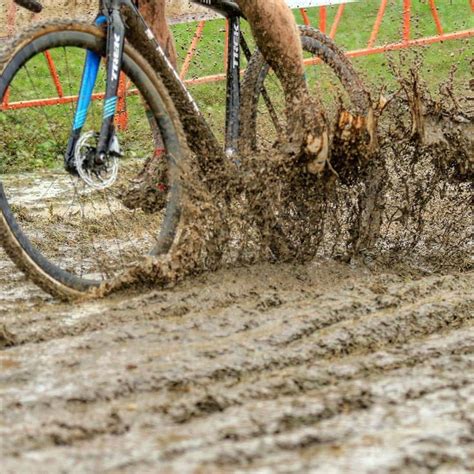 a man riding a bike through mud covered ground