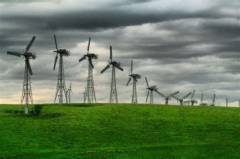 Grey Windmills On Green Grass Field Under Cloudy Sky Hd Wallpaper Wallpaper Flare