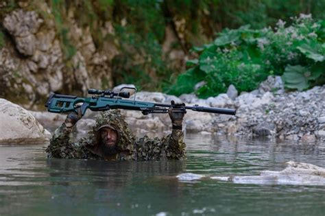 Un Militar O Un Jugador De Airsoft Con Un Traje De Camuflaje Se Esconde