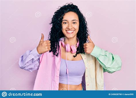 Young Hispanic Woman With Curly Hair Doing Thumbs Up Positive Gesture