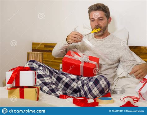 Preparando Presentes De Natal Jovem Feliz E Atraente Sentado Na Cama