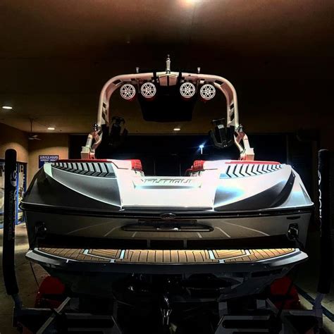 The Front End Of A White And Black Boat In A Room With Lights On It