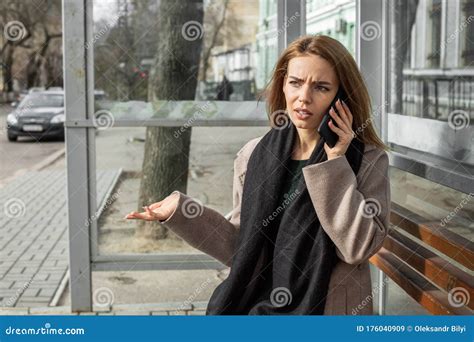 Girl Sitting At Bus Stop And Talking On The Phone Stock Image Image