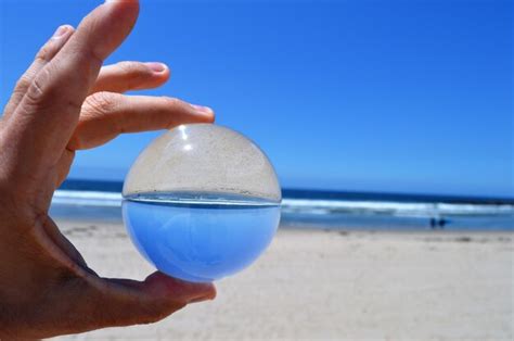 Premium Photo Cropped Hand Of Person Holding Crystal Ball At Beach