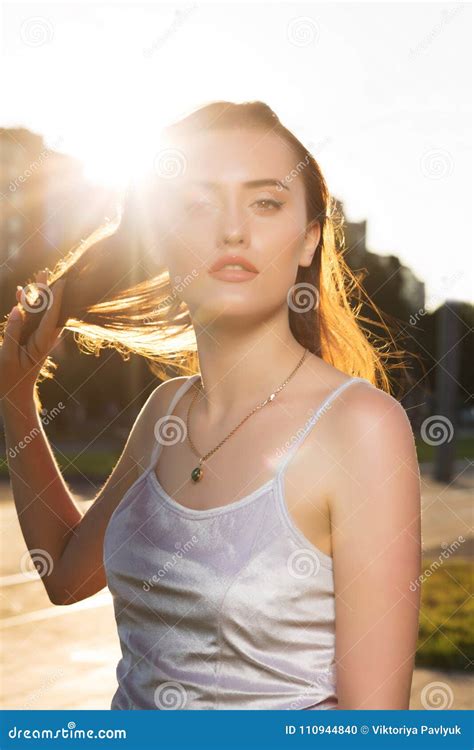 Adorable Brunette Woman With Natural Makeup Posing In Rays Of Sun At