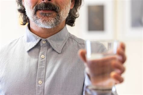 Hombre Feliz Sosteniendo Un Vaso De Agua Dentro Foto Premium