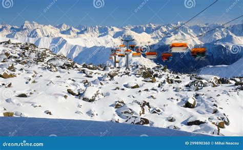 Orange Chairlift With Unrecognizable Skiers In Samnaun Ischgl