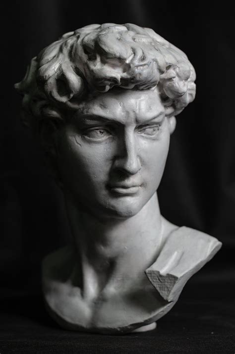 A White Marble Bust Of A Man With Curly Hair