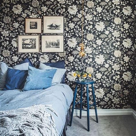 A Bedroom With Black And White Wallpaper Blue Bedding And Pictures On