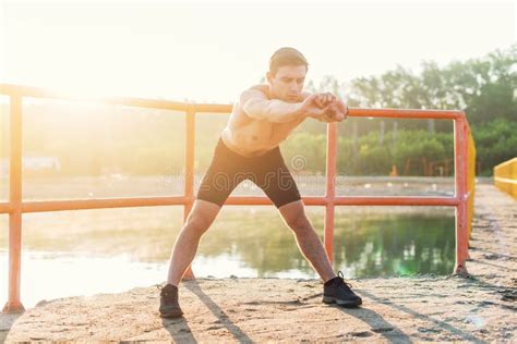 Hombre Deportivo Joven Que Dobla Adelante Y Que Hace Estirando