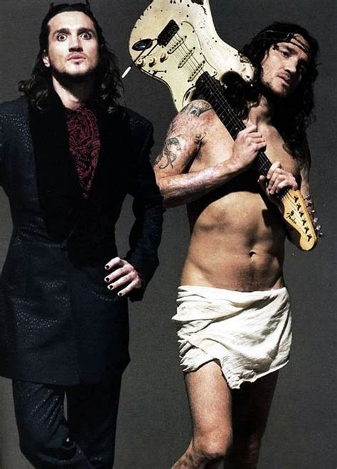 Two Men Are Posing With Guitars And One Is Holding A Guitar In His