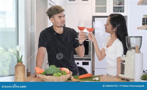 Romantic Young Couple Preparing Healthy Food And Drinking Wine At