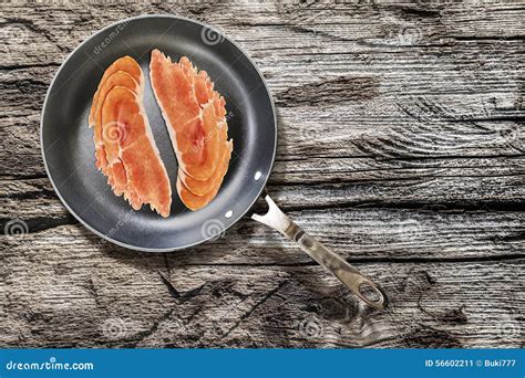 Prosciutto Rashers In Teflon Frying Pan Set On Old Cracked Wooden