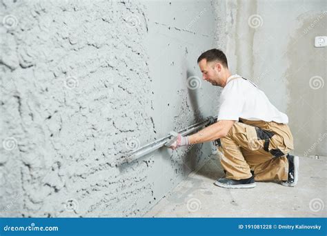 Plasterer Using Screeder Smoothing Putty Plaster Mortar On Wall Stock