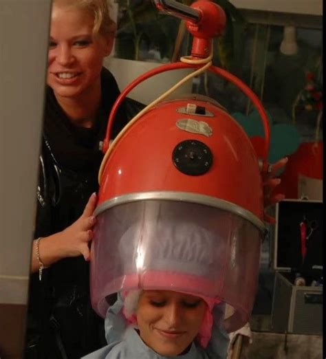 A Woman Is Getting Her Hair Cut By A Lady In A Salon With A Blow Dryer