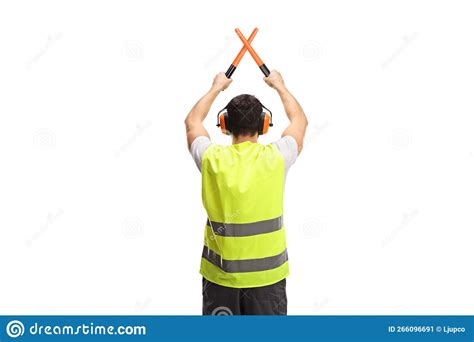 Rear View Shot Of An Marshaller Signalling With Crossed Wands Stock