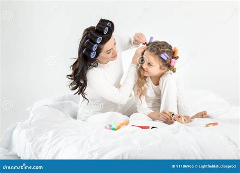 Mother Curling Hair To Daughter Applying Nail Polish On Toenails Stock Image Image Of