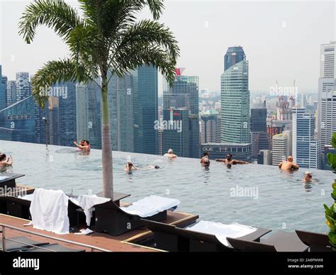 View Of People Enjoying The Rooftop Infinity Pool Of The Marina Bay