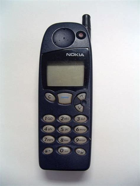 an old nokia cell phone sitting on top of a white table with the ...
