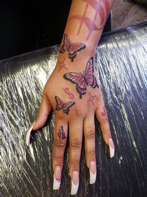 A Woman S Hand With Butterfly Tattoos On It