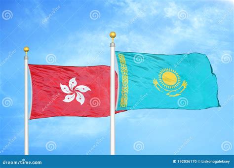 Hong Kong And Kazakhstan Two Flags On Flagpoles And Blue Cloudy Sky