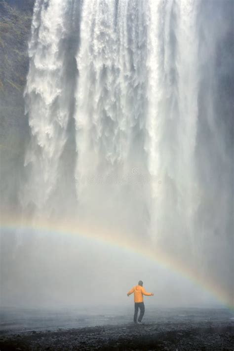 Tourist in Front of Skogafoss Waterfall. Rainbow at the Bottom of the ...