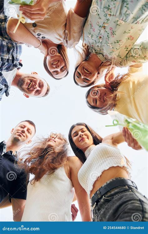 View From Below Of Young Positive People That Looking Down Stock Photo