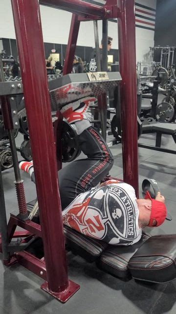 A Man Laying On Top Of A Bench In A Gym Next To A Barbell