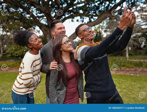 Group Of Multiracial Young Friends Standing Together In A Green Park