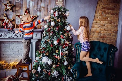 O Menino Bonito E A Menina Que Decora Uma Rvore De Natal Foto Gr Tis